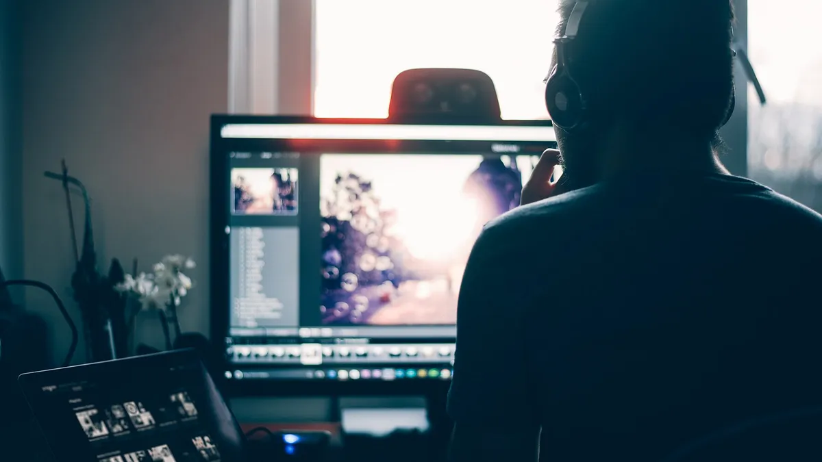 Laptop and monitor on a desk with images on the screens
